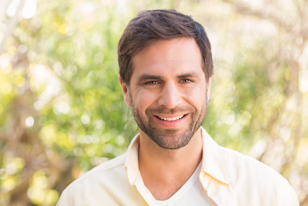 Happy man smiling at camera on a sunny day